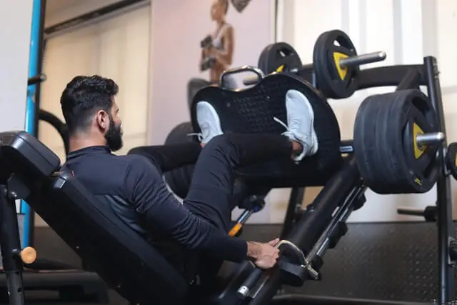 A man using the leg press machine inside a gym